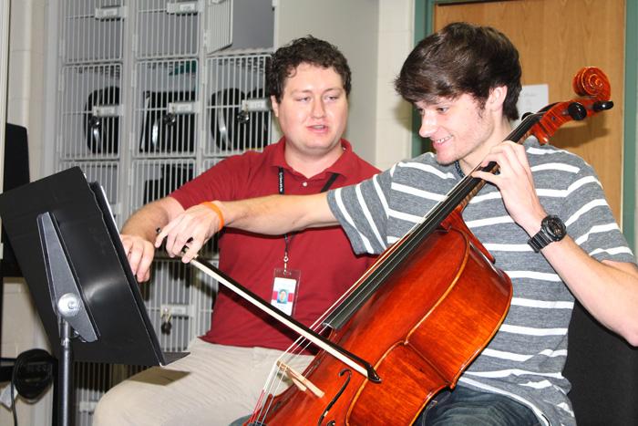 Orchestra director Nicholas Barnaby instructs junior Colton Boring during a private lesson.