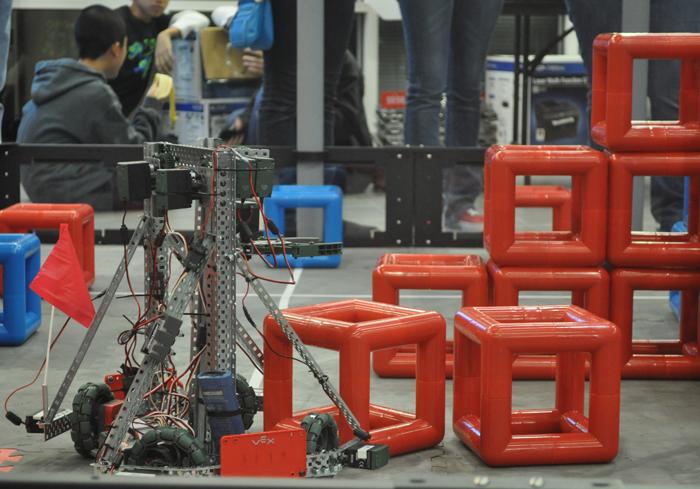 Amy 2.0 pushes cubes together while her partner bot stacks them. The bots had to work together to complete the task. 
