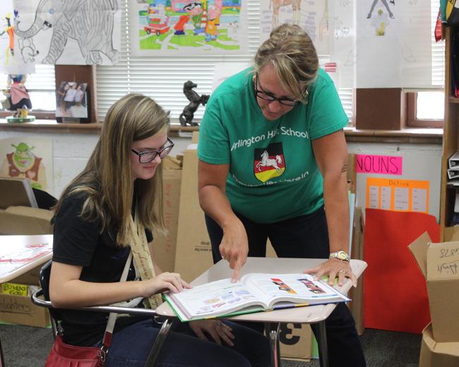 German teacher Susan West works with a student on an assignment during class.