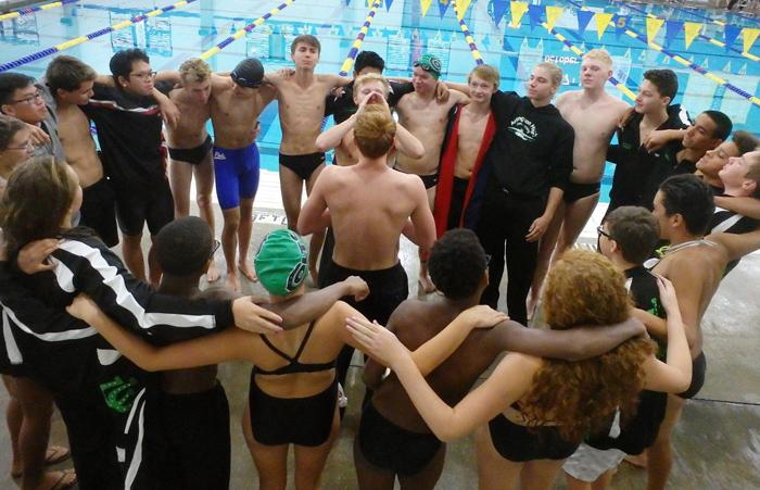 Seniors Austin Whitley and Dylan Nash lead the swim team in a team cheer before the start of the races.