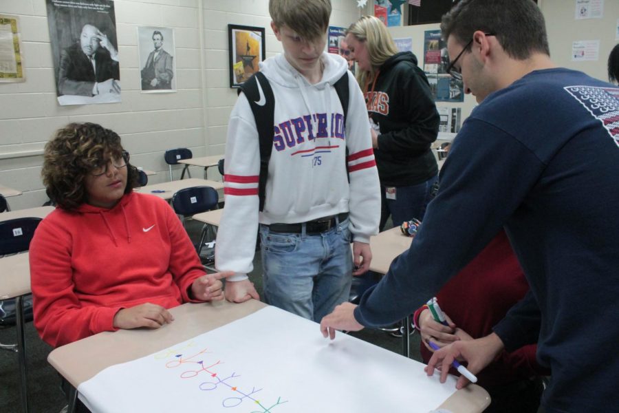 SPECTRUM Club president senior Teddy Holloway helps members design posters for national LGBTQ+ Bullying Awareness Day.