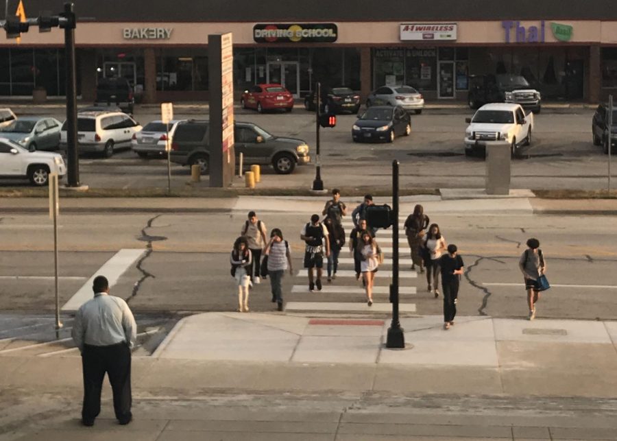 Principal Shahveer Dhalla watches students as they cross the new pedestrian crossing on their way into school. The City of Arlington installed the crossing in August to give people going to and from AHS added safety.