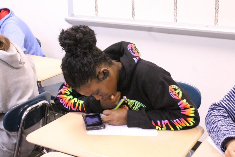 A student uses her phone during math class to watch a video to further her understanding of the assignment.